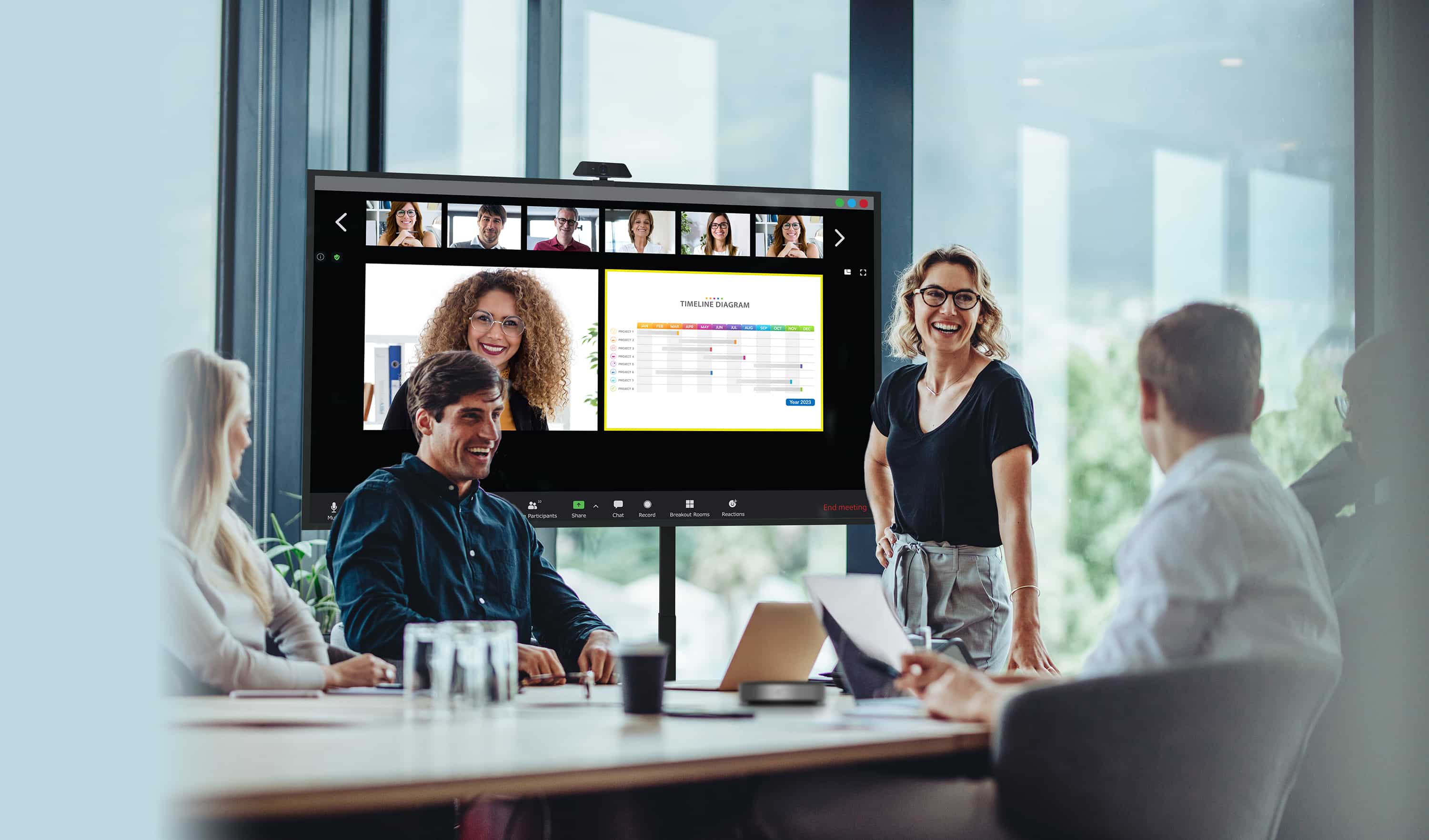 Geschäftsleute, die eine Besprechung durchführen, bei der einige Mitarbeiter physisch anwesend sind, schauen auf ein Display der Optoma N-Serie, während ihre externen Kollegen auf dem Bildschirm neben den Inhalten, die sie teilen, angezeigt werden.